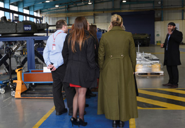 four people on a factory  floor 