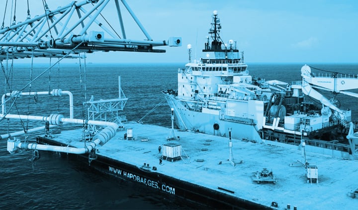 a ship on the sea next to a platform - in blue 