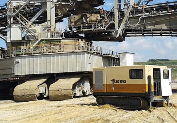 two construction vehicles on tracks in the desert 