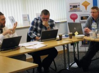 Team members collaborating around a table during a process mapping workshop